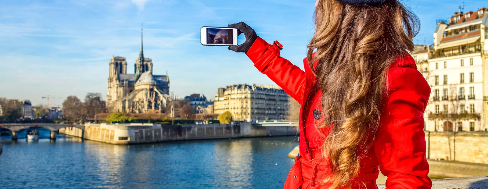 A traveler taking in the view of Notre-Dame de Paris across the Seine
